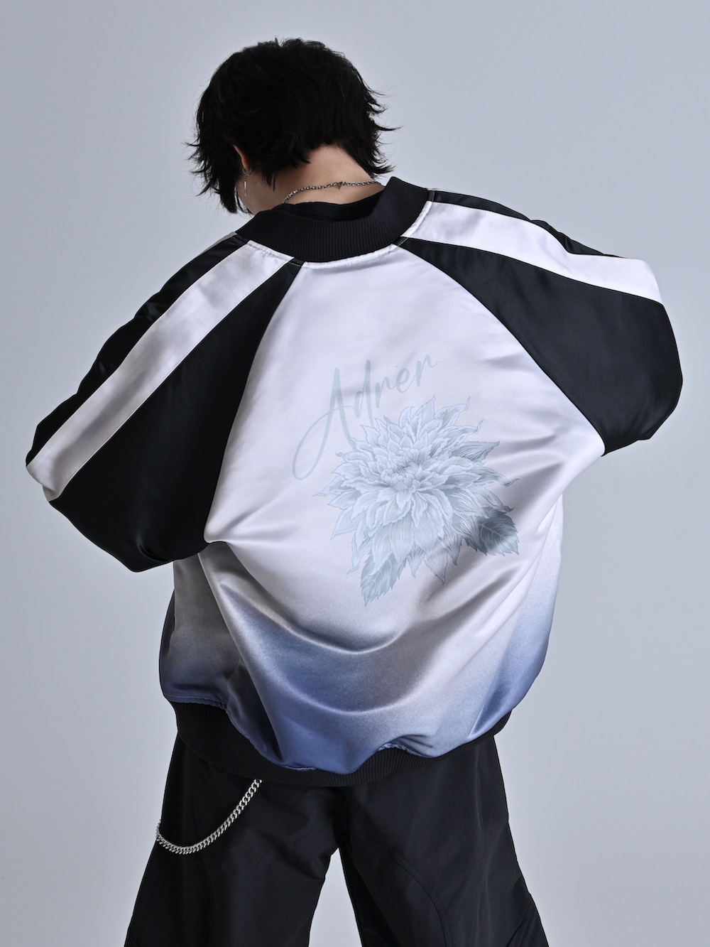 ブラック系のスウェットパンツ、ブラック系のスニーカー、ブラック系のスカジャンを着用したメンズの冬コーディネートの4枚目の写真