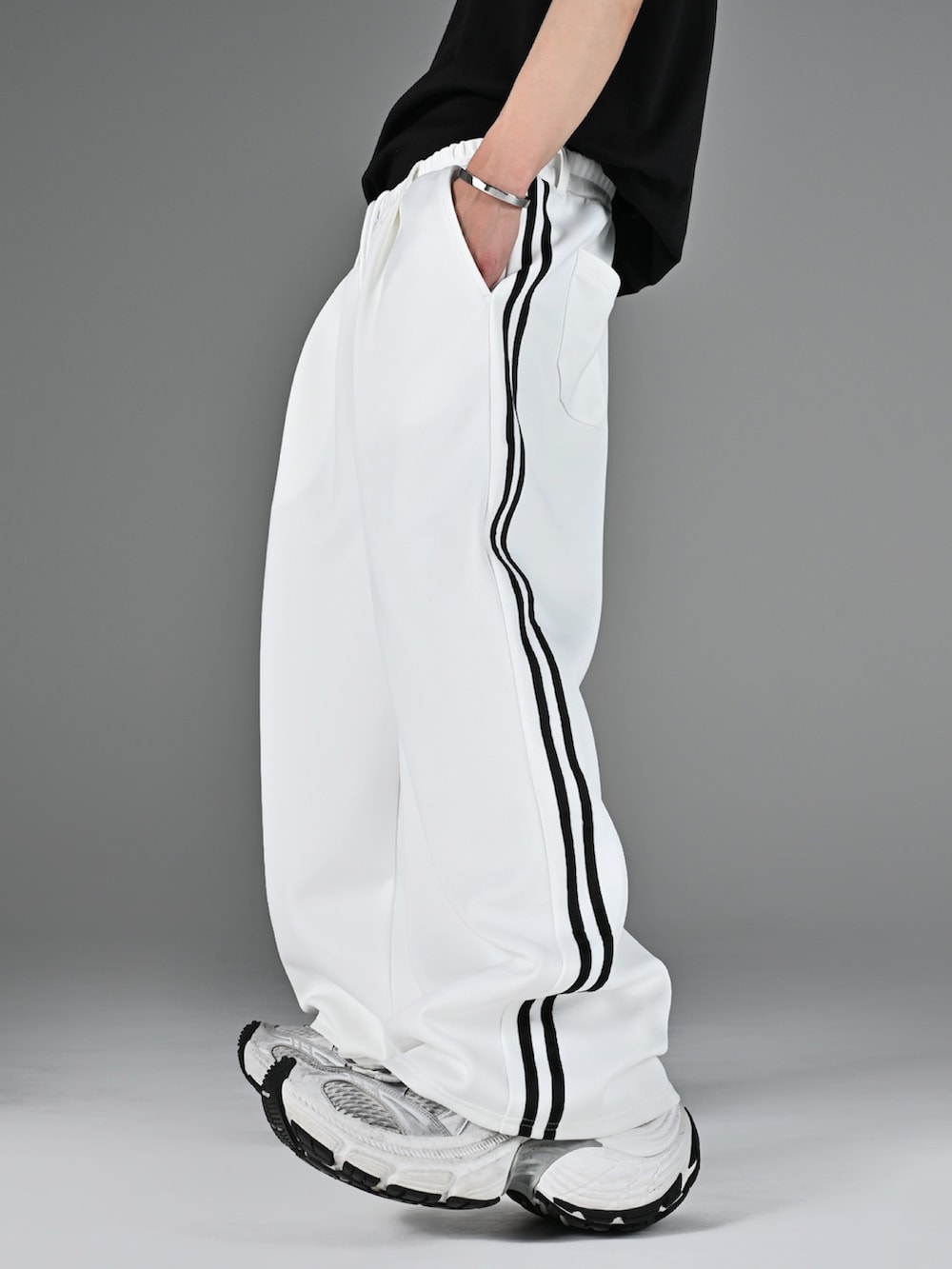 レッド系のタンクトップ、ホワイト系のスニーカー、ホワイト系のブルゾンを着用したメンズの冬コーディネートの4枚目の写真