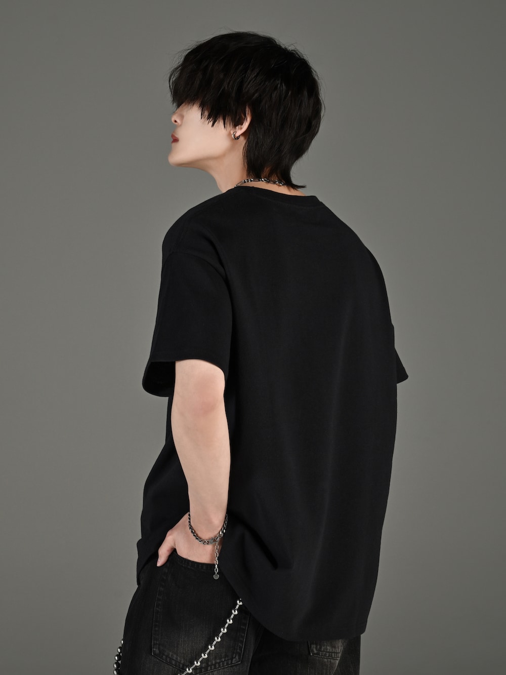 ブラック系のデニムパンツ、ブラック系のブーツ、ブラック系のショルダーバッグを着用したメンズの春コーディネートの4枚目の写真