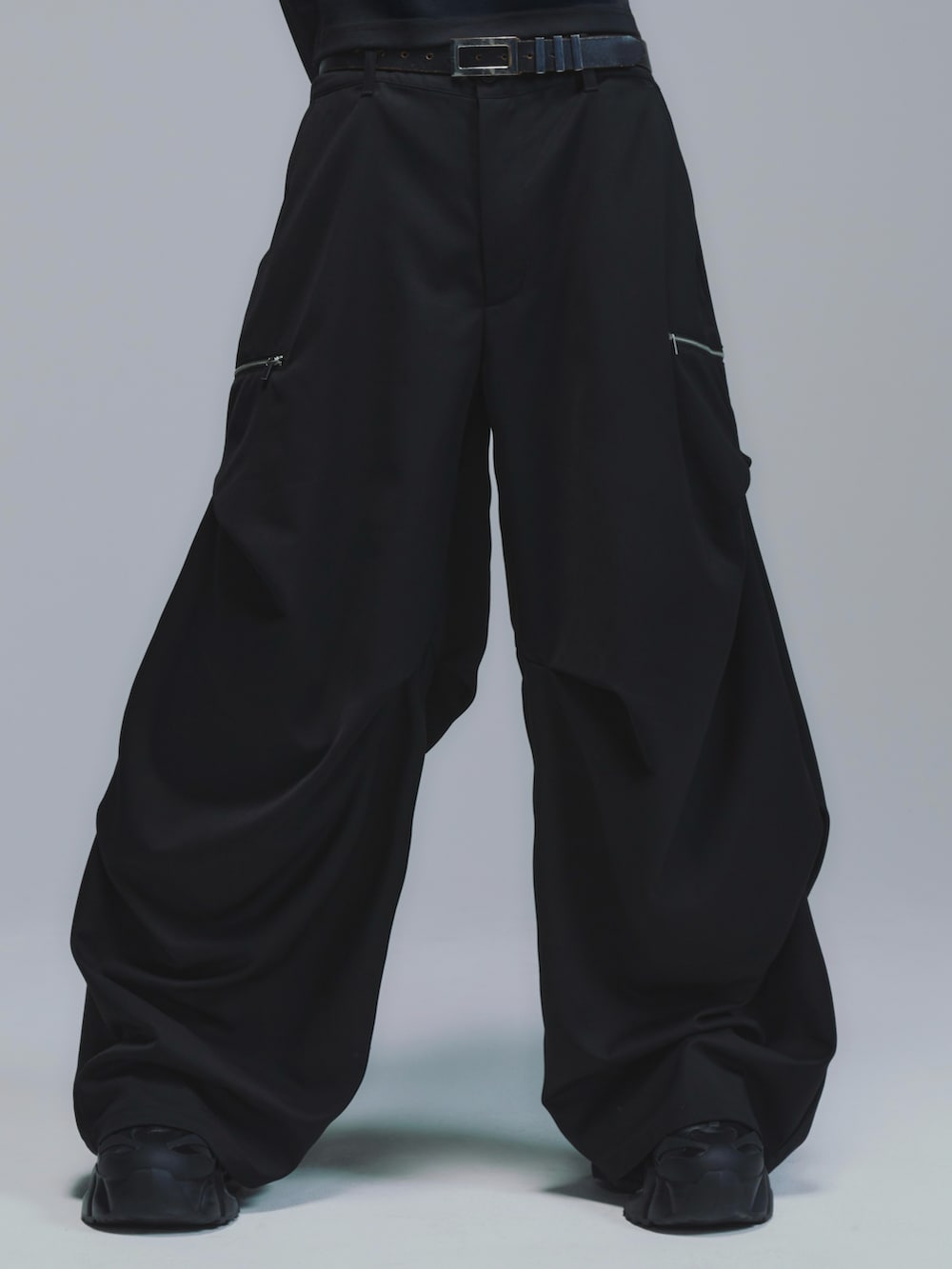 ブラック系のTシャツ/カットソー、ブラック系のスラックス、ブラック系のスニーカーを着用したメンズの冬コーディネートの2枚目の写真