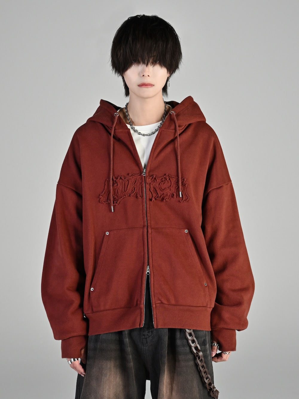 ホワイト系のスニーカー、ブラウン系のパーカー、ブラック系のデニムパンツを着用したメンズの秋コーディネートの2枚目の写真