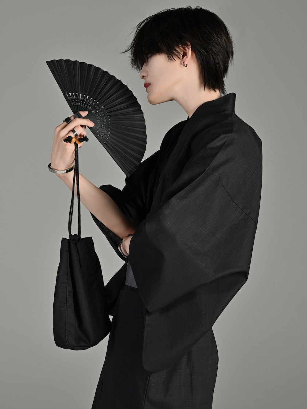 シルバー系のピアス（両耳用）、シルバー系のメガネ、シルバー系のバングル/リストバンドを着用したメンズの夏コーディネートの3枚目の写真