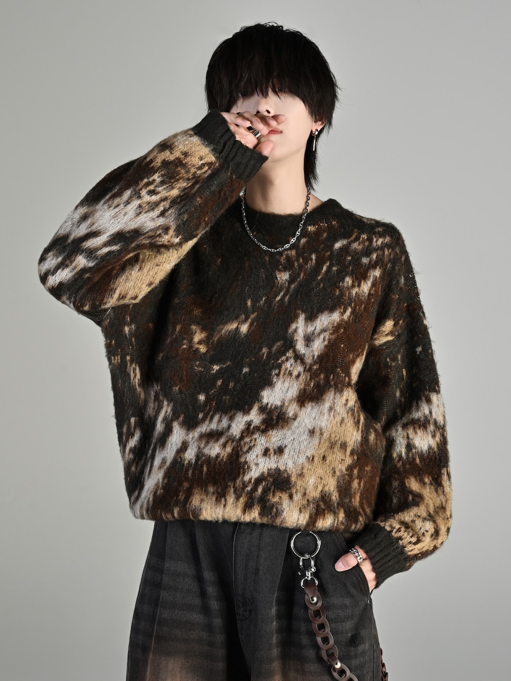 ブラック系のスニーカー、ブラウン系のニット/セーター、ブラック系のデニムパンツを着用したメンズの秋コーディネートの3枚目の写真