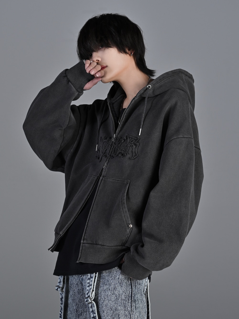 ブラック系のショルダーバッグ、ブラック系のスニーカー、グレー系のパーカーを着用したメンズの冬コーディネートの3枚目の写真