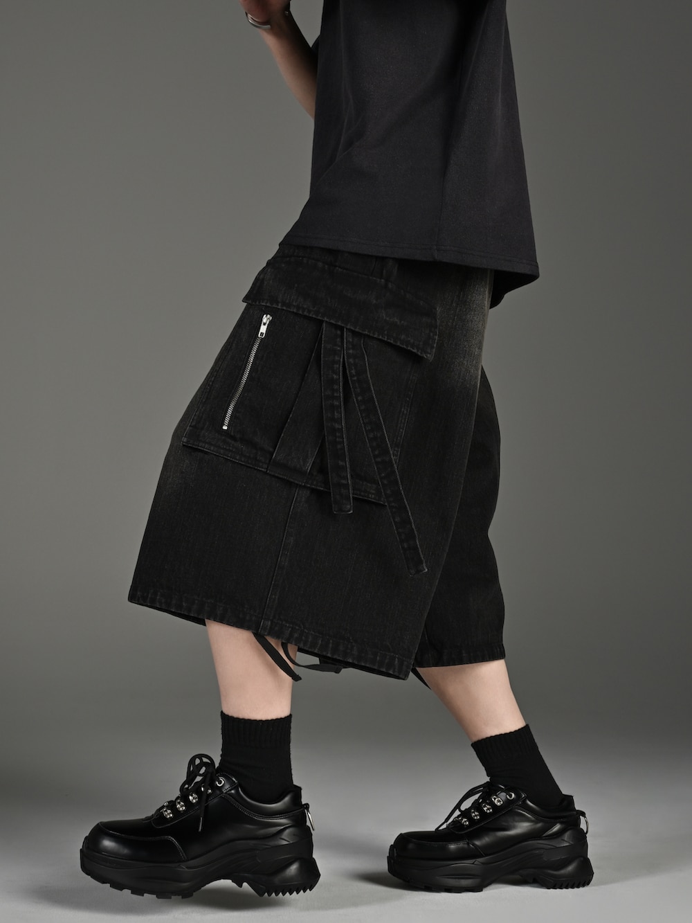 ホワイト系のスニーカー、ブラック系のTシャツ/カットソー、ブラック系のカーゴパンツを着用したメンズの春コーディネートの3枚目の写真