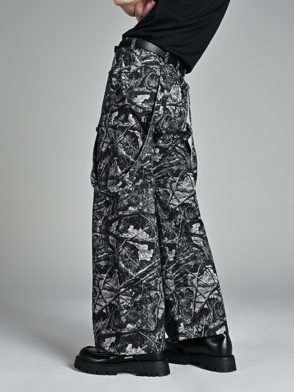 レッド系のタンクトップ、ブラック系のローファー、ブラック系のパーカーを着用したメンズの夏コーディネートの3枚目の写真