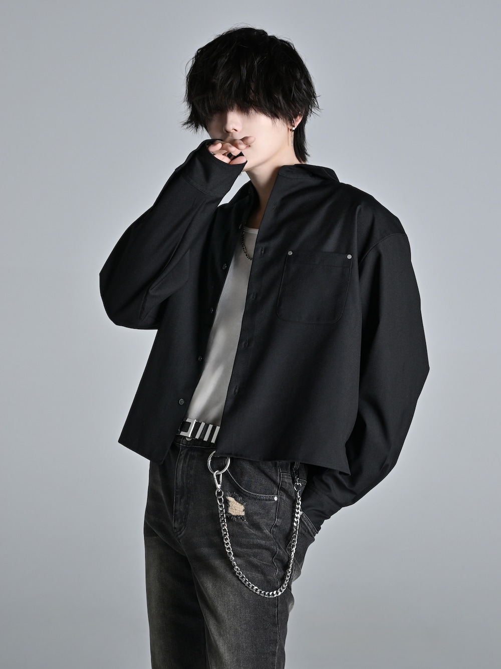 ブラック系のデニムパンツ、ブラック系のショルダーバッグ、ブラック系のスニーカーを着用したメンズの冬コーディネートの2枚目の写真