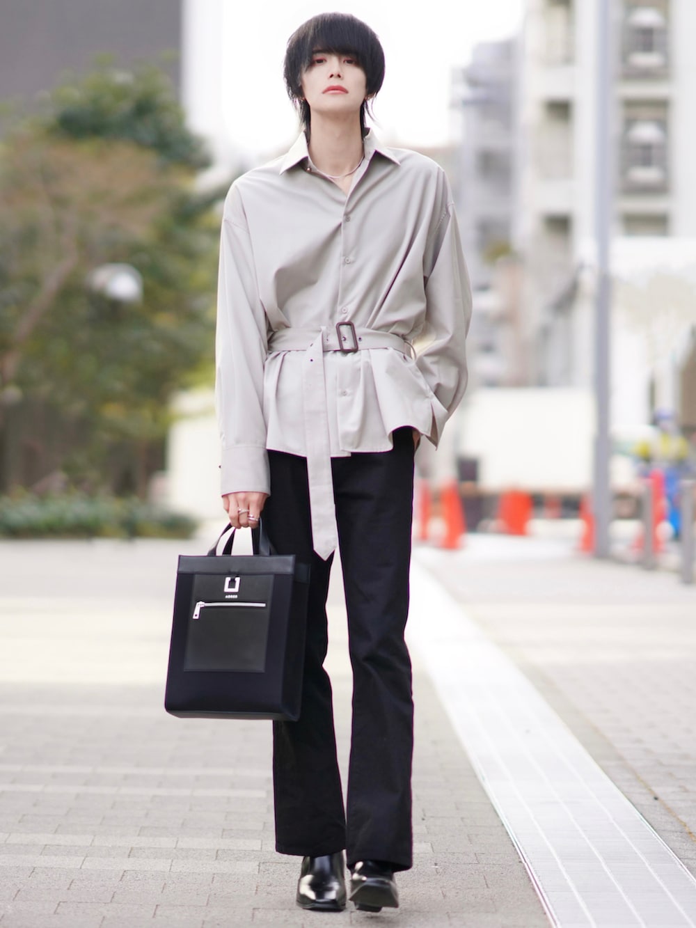 ホワイト系のテーラードジャケット、ブラック系のデニムパンツ、ブラック系のブーツを着用したメンズの春コーディネートの3枚目の写真