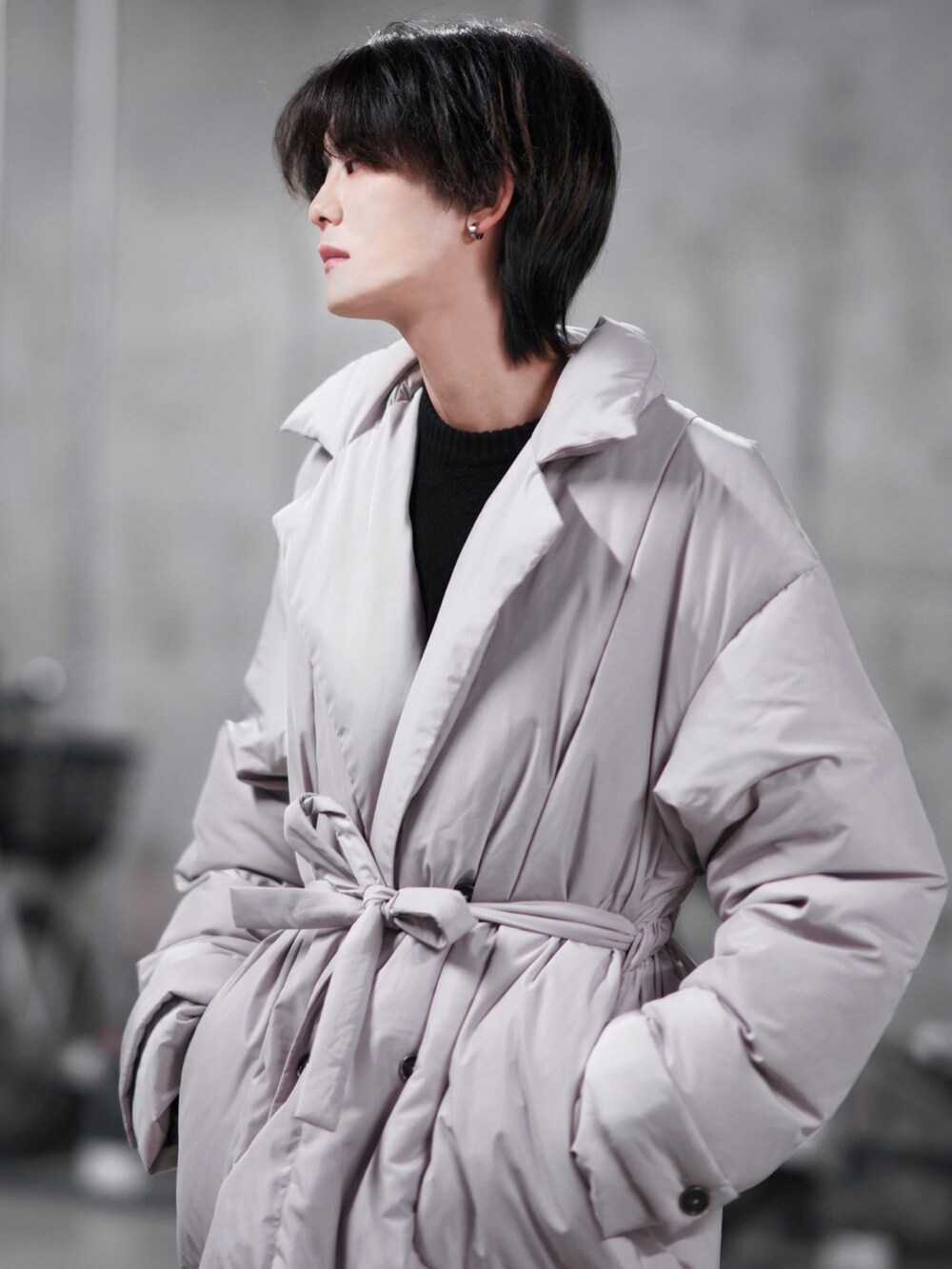 ブラック系のニット/セーター、ブラック系のスラックス、ベージュ系のダウンジャケット/コートを着用したメンズの冬コーディネートの5枚目の写真