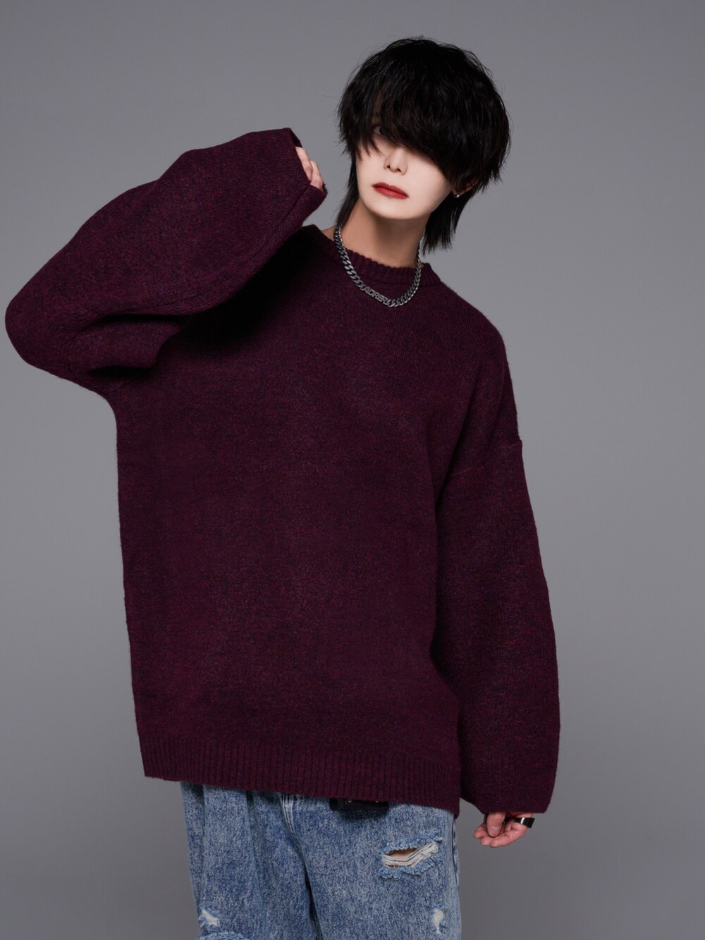 ブルー系のデニムパンツ、ホワイト系のスニーカー、レッド系のニット/セーターを着用したメンズの秋コーディネートの4枚目の写真