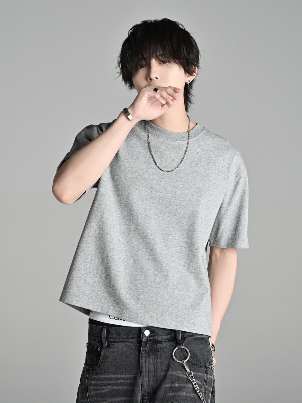 グレー系のTシャツ/カットソー、ブラック系のデニムパンツ、ブラウン系のブーツを着用したメンズの春コーディネートの2枚目の写真