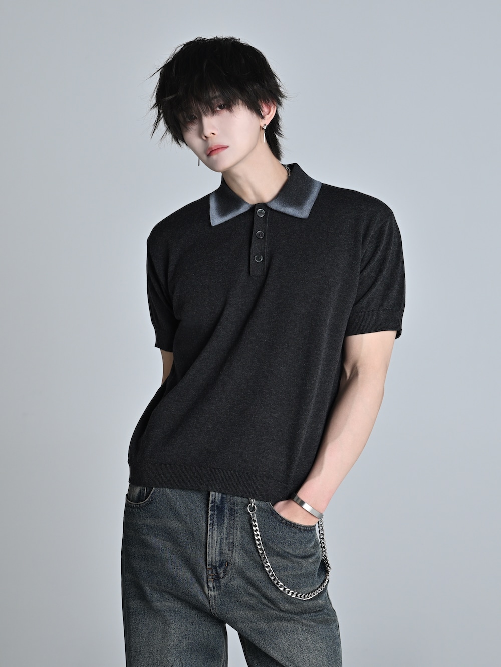 ブルー系のデニムパンツ、グレー系のポロシャツ、ブラック系のショルダーバッグを着用したメンズの春コーディネートの4枚目の写真