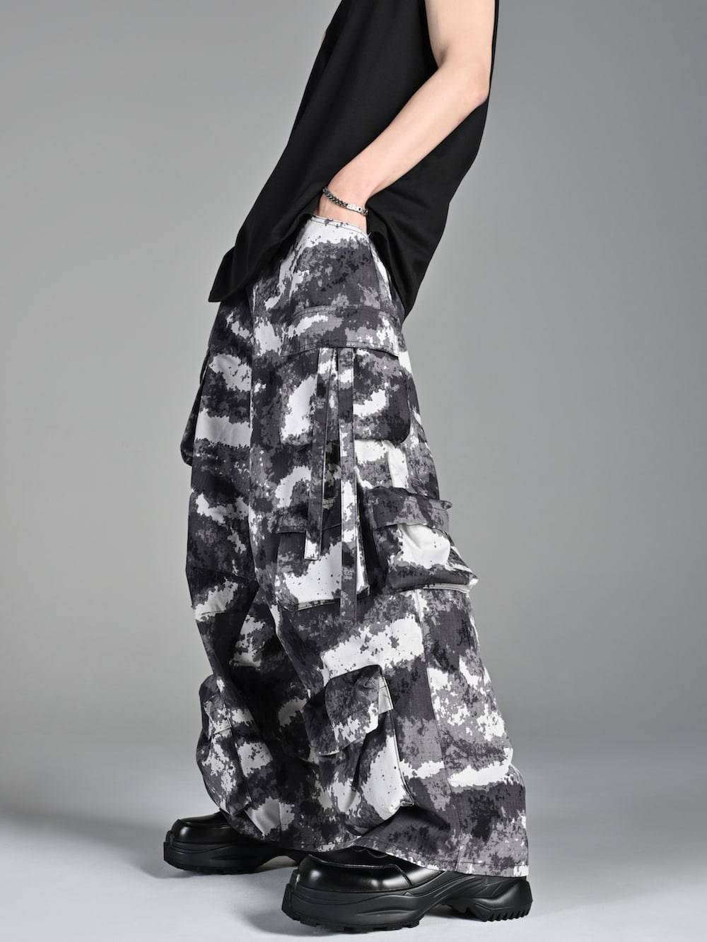 レッド系のタンクトップ、ブラック系のスニーカー、ブラック系のショルダーバッグを着用したメンズの夏コーディネートの3枚目の写真