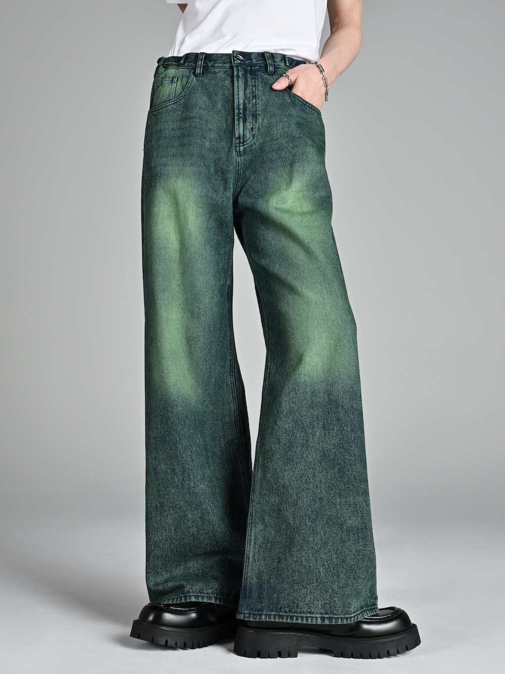 グレー系のタンクトップ、ブルー系のデニムパンツ、ホワイト系のスニーカーを着用したメンズの冬コーディネートの2枚目の写真