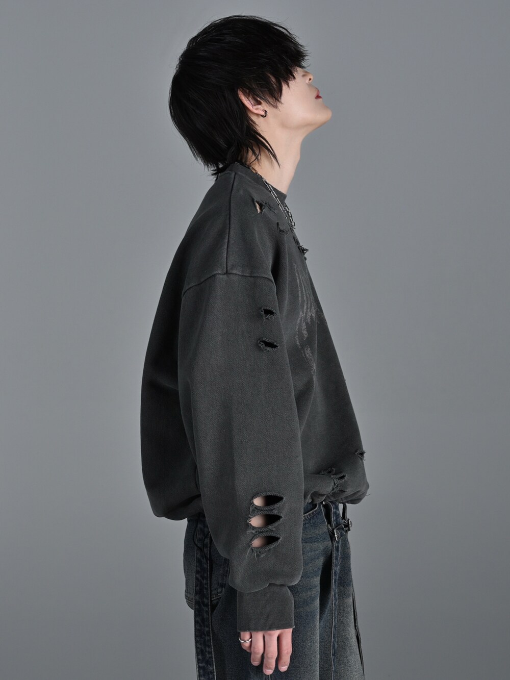 ブラウン系のスウェット、ブラック系のデニムパンツ、ホワイト系のスニーカーを着用したメンズの冬コーディネートの3枚目の写真