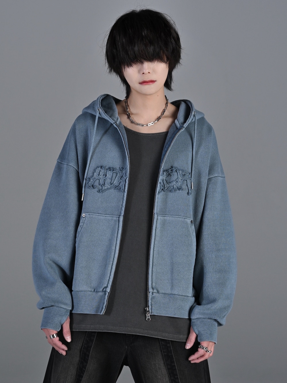 ブラック系のデニムパンツ、ホワイト系のスニーカー、ブラック系のショルダーバッグを着用したメンズの冬コーディネートの2枚目の写真