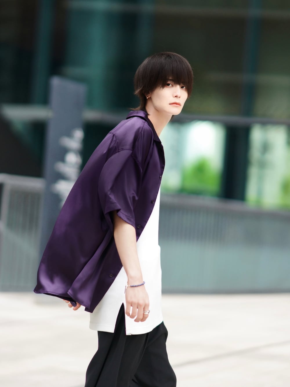 ブラック系のスラックス、ブラック系のブーツ、ベージュ系のトートバッグを着用したメンズの春コーディネートの4枚目の写真