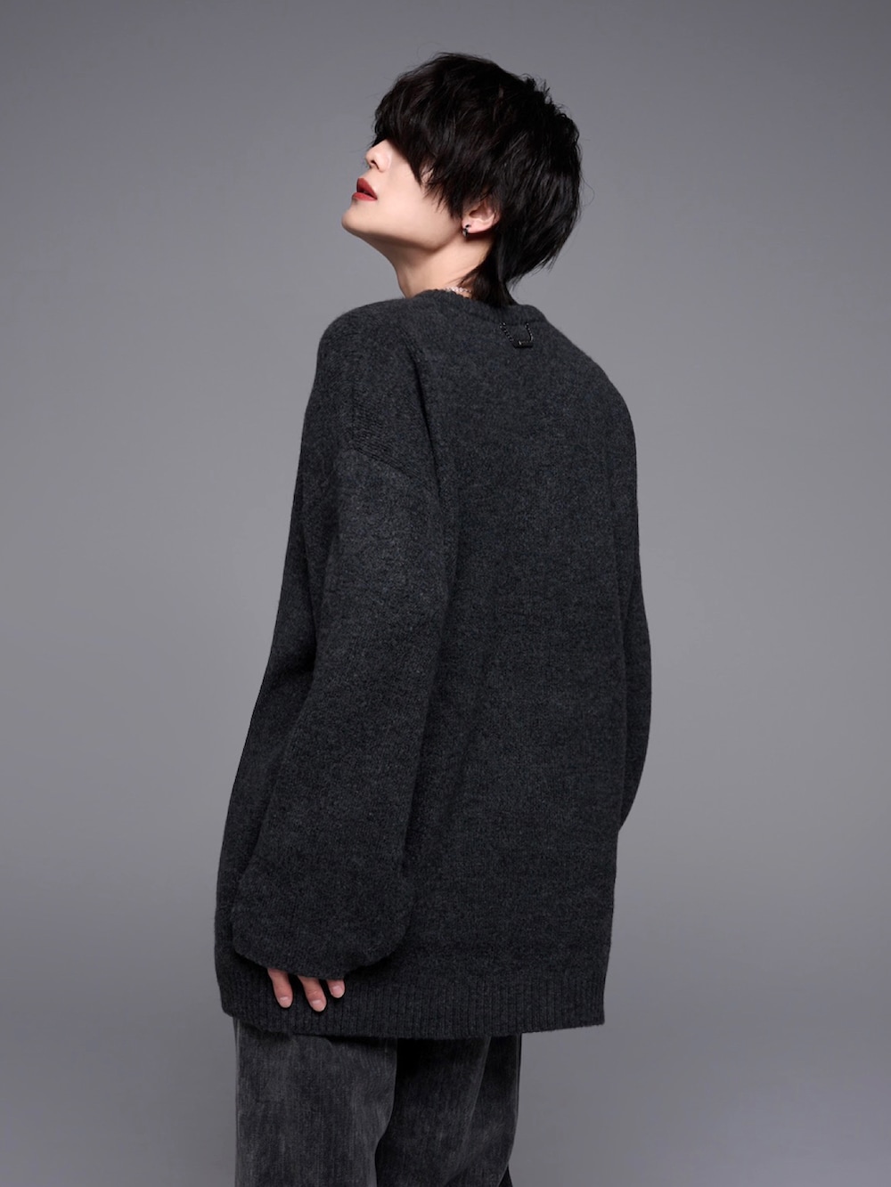 ブラック系のデニムパンツ、ブラック系のローファー、ブラック系のニット/セーターを着用したメンズの秋コーディネートの5枚目の写真