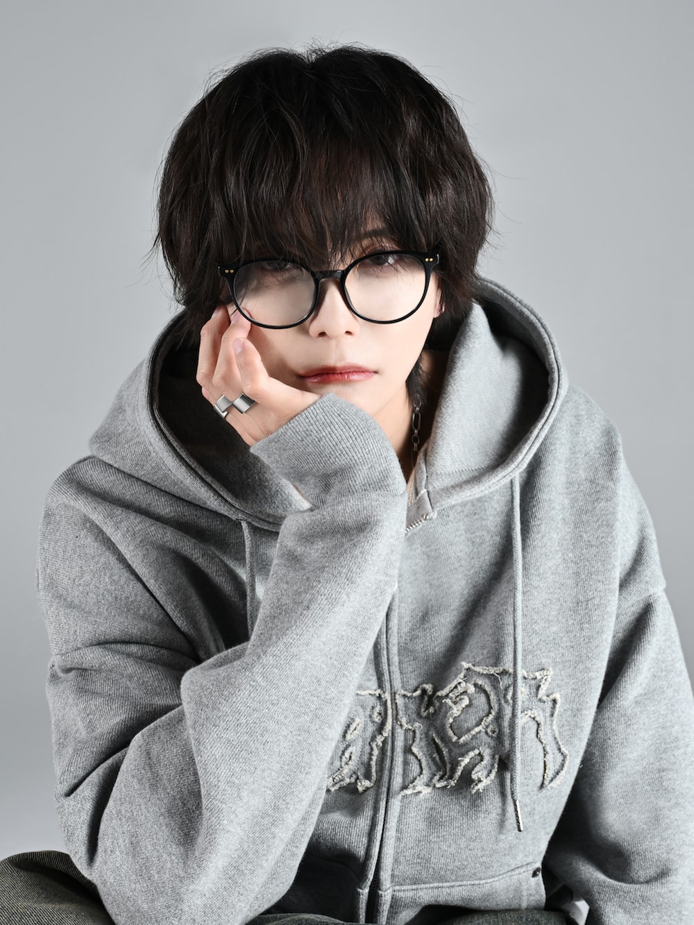 グレー系のタンクトップ、グレー系のパーカー、ブラック系のスラックスを着用したメンズの秋コーディネートの3枚目の写真