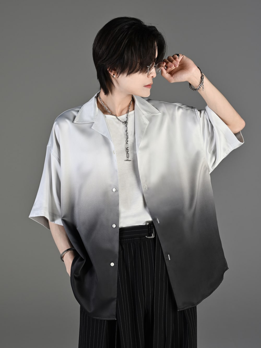 ブラック系のスラックス、ブラック系のブーツ、ブラック系のシャツ/ブラウスを着用したメンズの春コーディネートの2枚目の写真