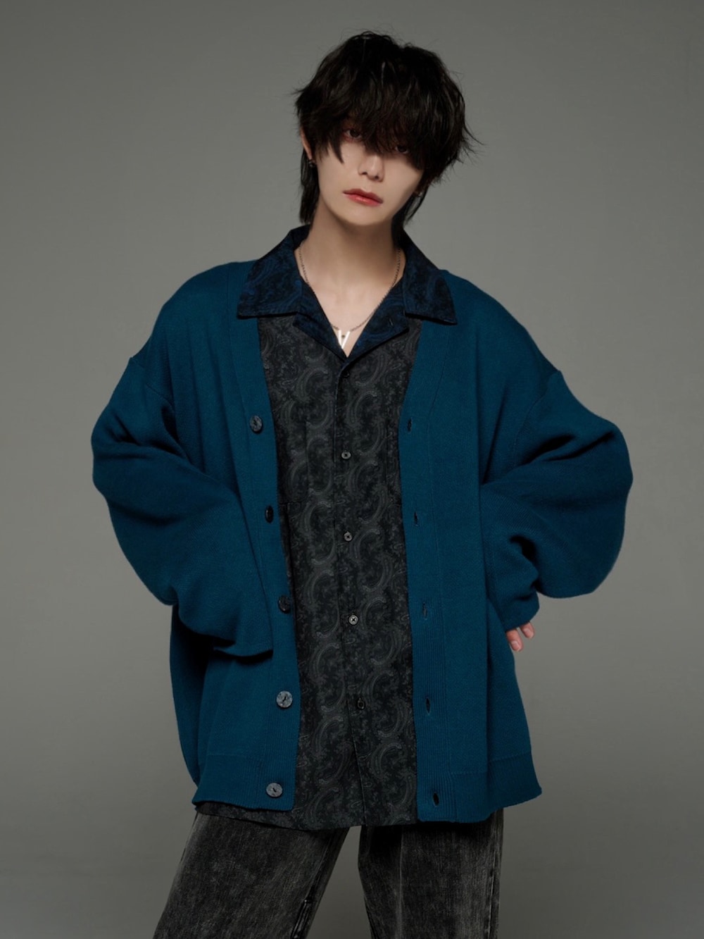 ブラック系のデニムパンツ、ブラック系のブーツ、グリーン系のカーディガン/ボレロを着用したメンズの秋コーディネートの3枚目の写真