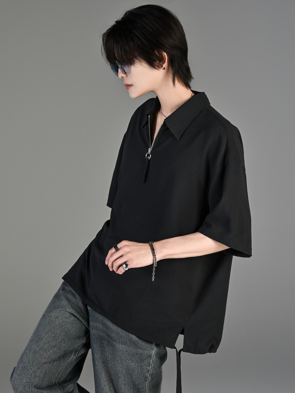 ブルー系のデニムパンツ、ブラック系のブーツ、ブラック系のショルダーバッグを着用したメンズの春コーディネートの2枚目の写真