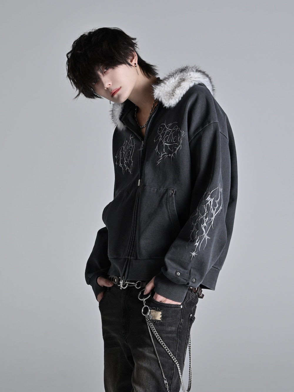 ブラック系のパーカー、ブラック系のデニムパンツ、ホワイト系のスニーカーを着用したメンズの冬コーディネートの3枚目の写真