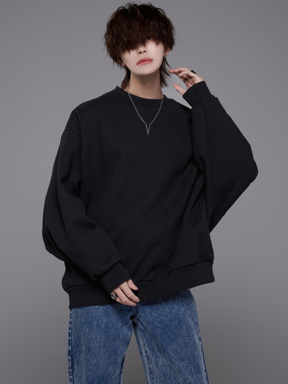 ブラック系のデニムパンツ、ブラック系のスウェット、ブルー系のデニムパンツを着用したメンズの冬コーディネートの2枚目の写真