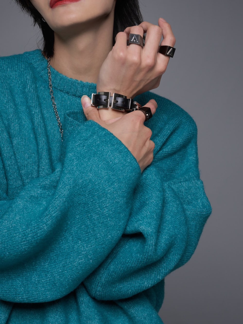 ブラック系のデニムパンツ、ブラック系のスニーカー、グリーン系のニット/セーターを着用したメンズの秋コーディネートの3枚目の写真