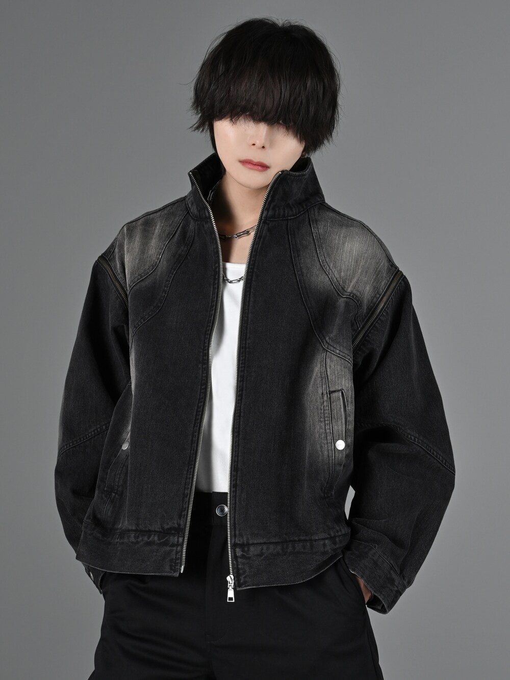 グレー系のタンクトップ、ブラック系のスラックス、ブラック系のブーツを着用したメンズの冬コーディネートの2枚目の写真