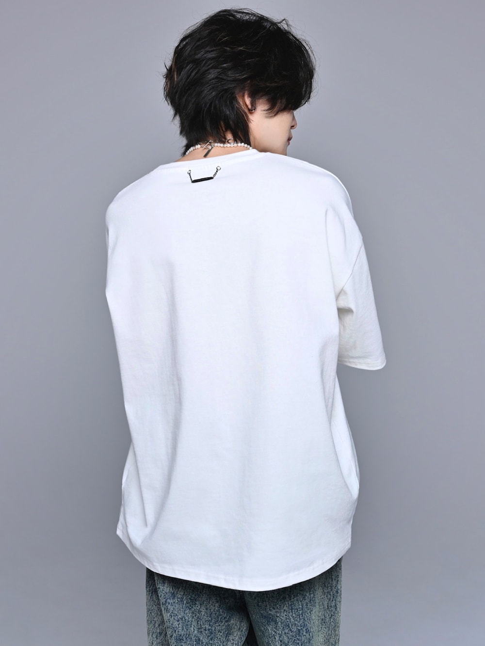 ホワイト系のスニーカー、ベージュ系のデニムパンツ、ホワイト系のTシャツ/カットソーを着用したメンズの春コーディネートの5枚目の写真