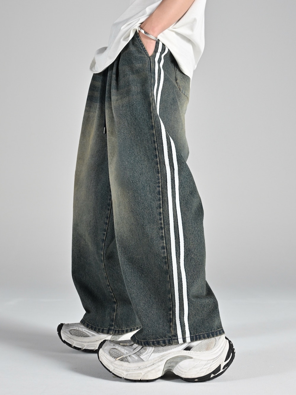 ベージュ系のブーツ、グレー系のタンクトップ、ブルー系のブルゾンを着用したメンズの夏コーディネートの3枚目の写真