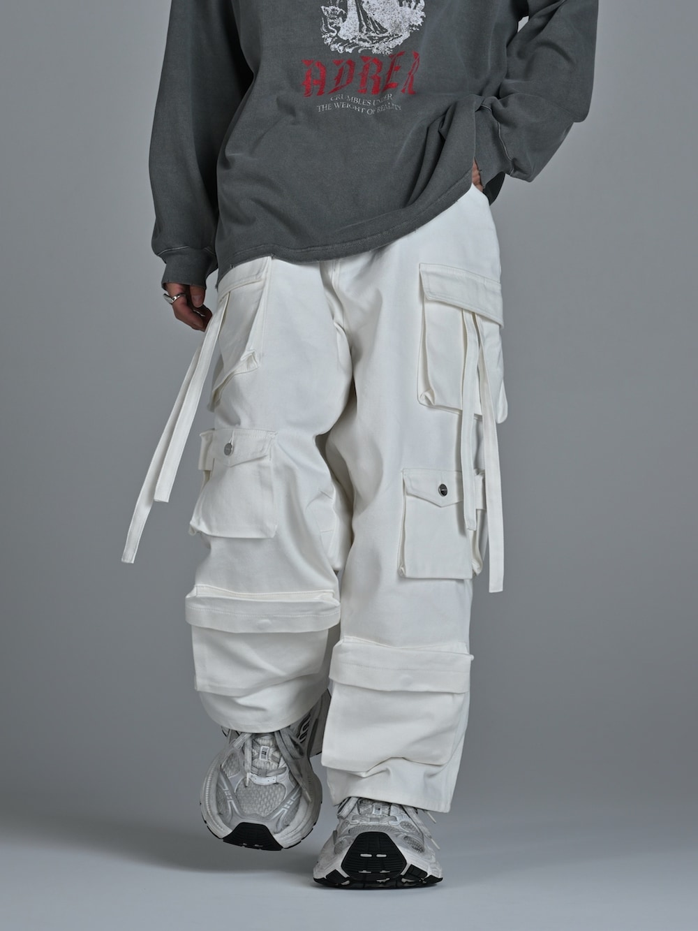 ホワイト系のスニーカー、グレー系のTシャツ/カットソー、ホワイト系のカーゴパンツを着用したメンズの秋コーディネートの4枚目の写真