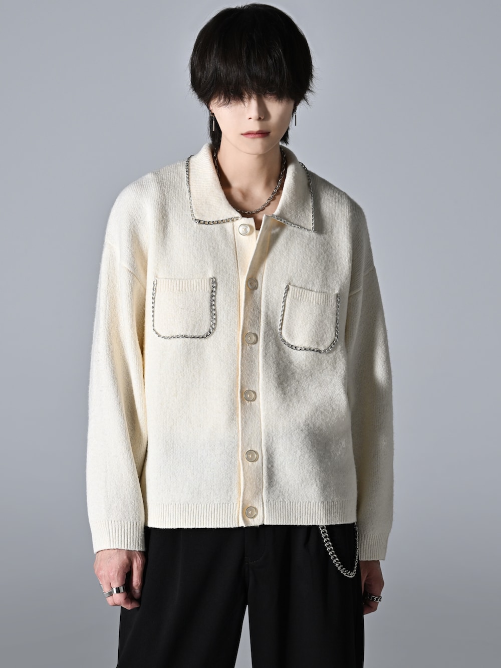 ブラック系のスラックス、ブラック系のローファー、ホワイト系のカーディガン/ボレロを着用したメンズの秋コーディネートの4枚目の写真