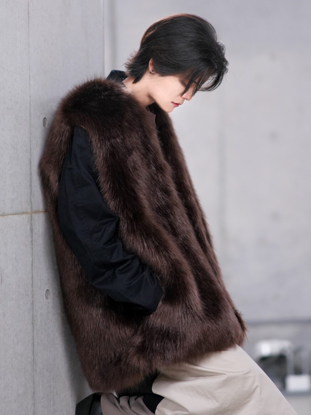 ベージュ系のトレンチコート、ブラック系のブーツ、ベージュ系のトートバッグを着用したメンズの冬コーディネートの4枚目の写真