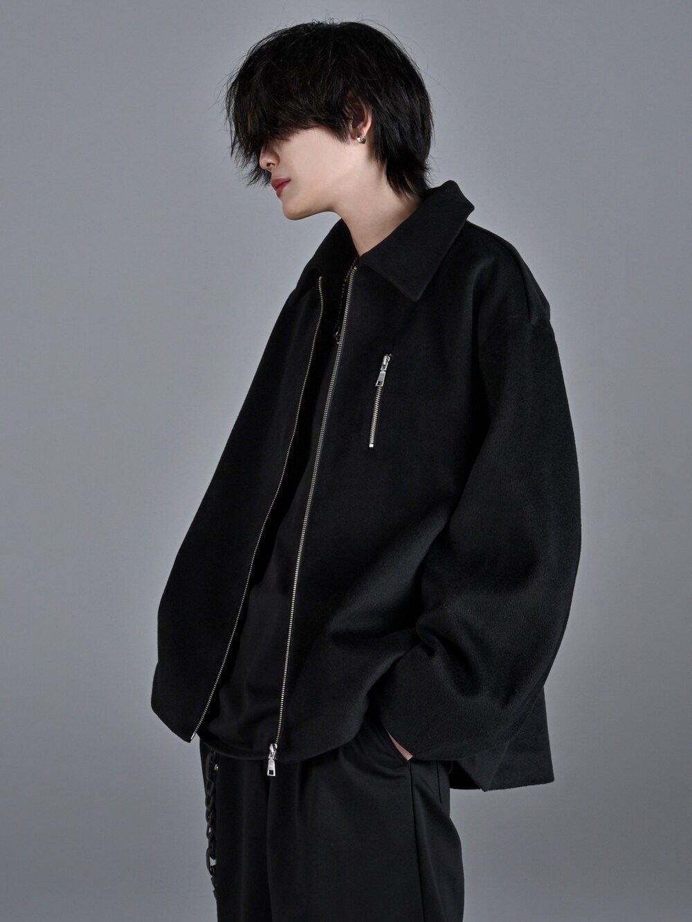 ブラック系のタンクトップ、ブラック系のスラックス、ホワイト系のスニーカーを着用したメンズの秋コーディネートの3枚目の写真