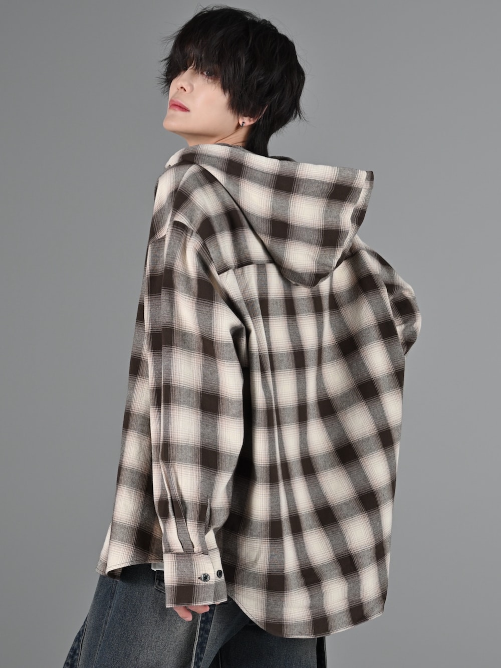 グレー系のタンクトップ、ブルー系のデニムパンツ、ブラック系のブーツを着用したメンズの冬コーディネートの3枚目の写真