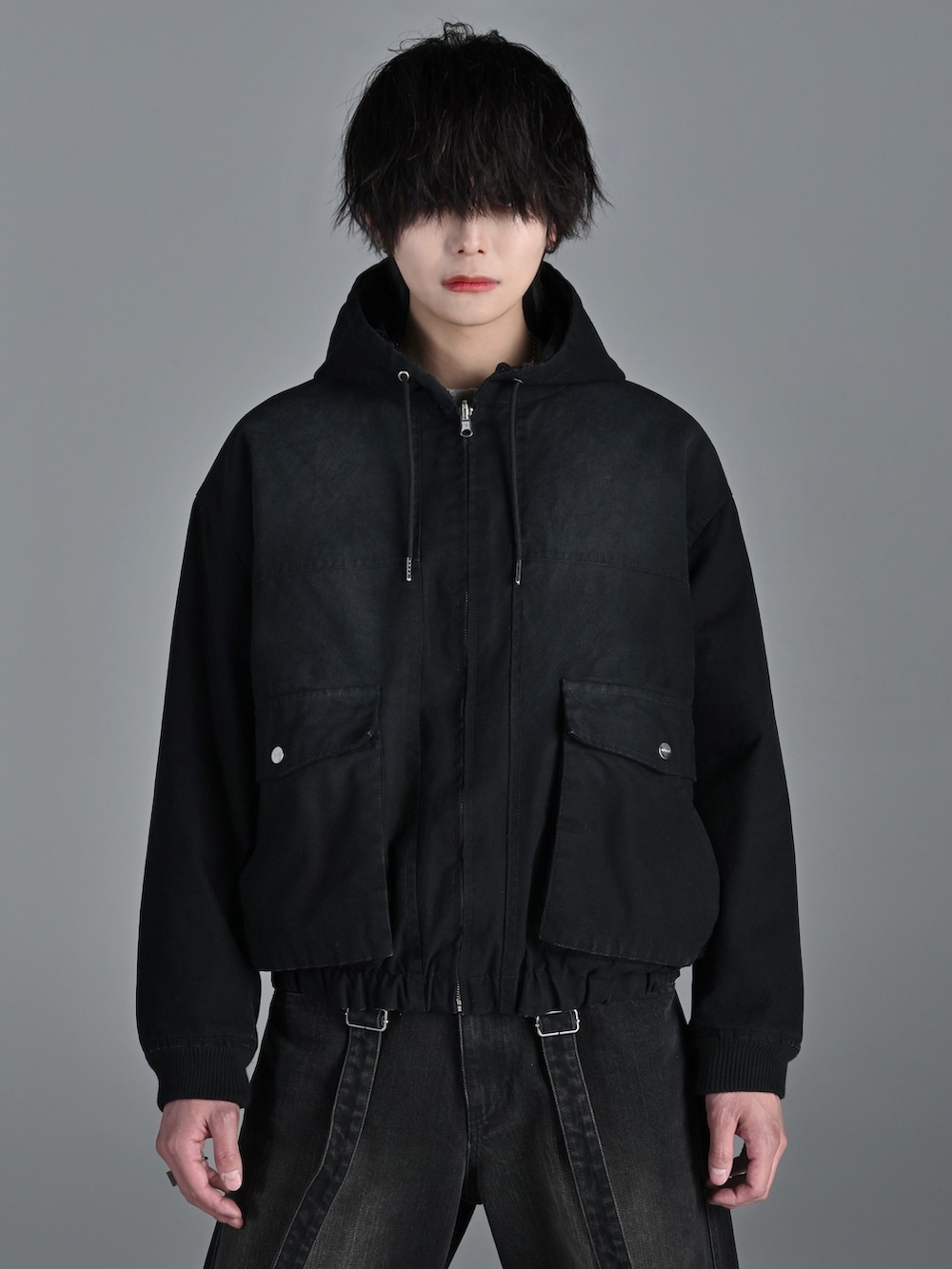 ブラック系のブルゾン、ブラック系のデニムパンツ、ホワイト系のスニーカーを着用したメンズの冬コーディネートの2枚目の写真