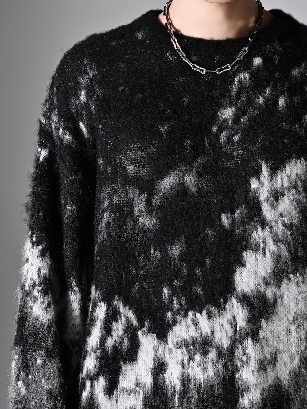 ブラック系のニット/セーター、ブラック系のショルダーバッグ、グレー系のデニムパンツを着用したメンズの秋コーディネートの3枚目の写真