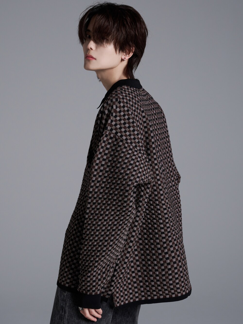 ブラック系のデニムパンツ、ブラウン系のポロシャツ、ブラック系のブーツを着用したメンズの冬コーディネートの4枚目の写真