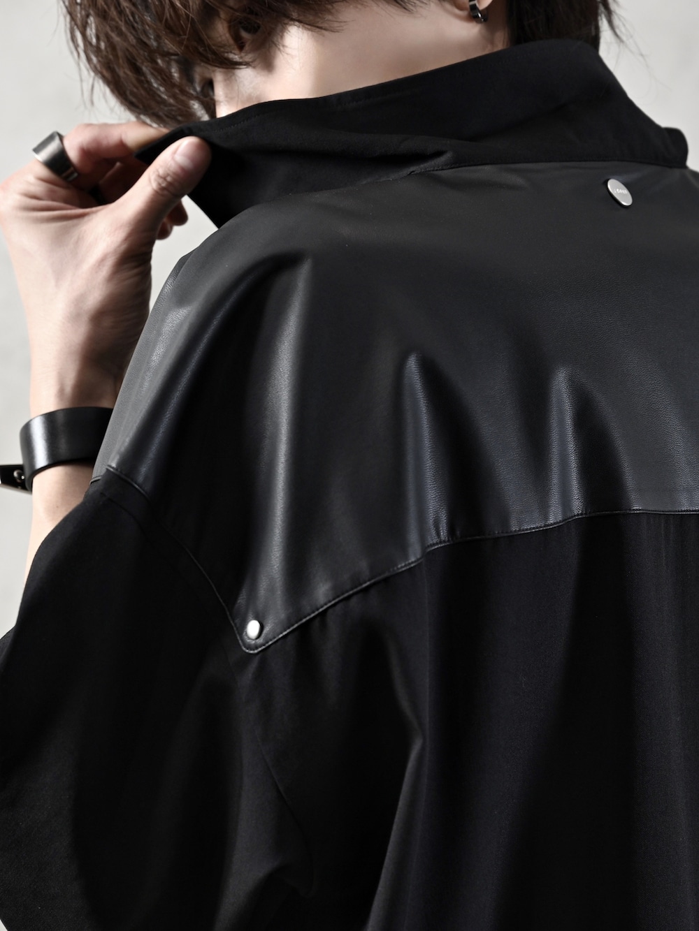 ブラック系のデニムパンツ、ブラック系のブーツ、ブラック系のショルダーバッグを着用したメンズの春コーディネートの5枚目の写真