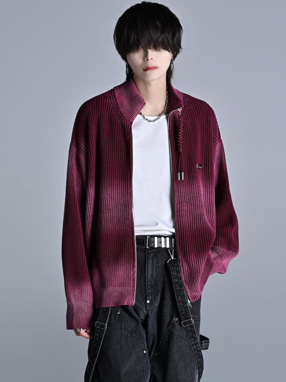 レッド系のニット/セーター、ブラック系のデニムパンツ、ブラック系のスニーカーを着用したメンズの秋コーディネートの5枚目の写真