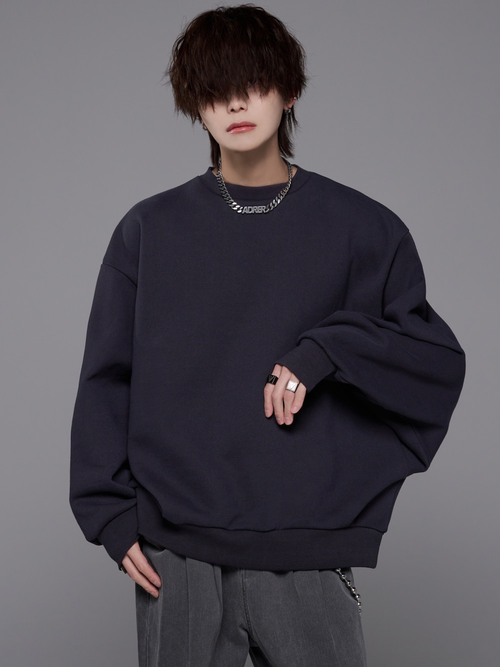 グレー系のデニムパンツ、グレー系のスウェット、ブラック系のブーツを着用したメンズの冬コーディネートの3枚目の写真