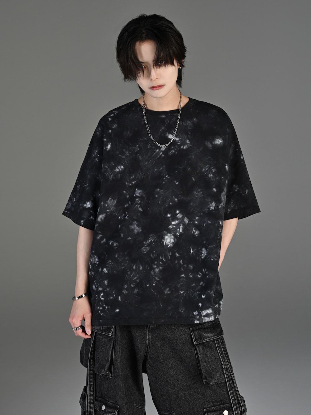 グレー系のタンクトップ、ブラック系のカーゴパンツ、ホワイト系のスニーカーを着用したメンズの春コーディネートの3枚目の写真