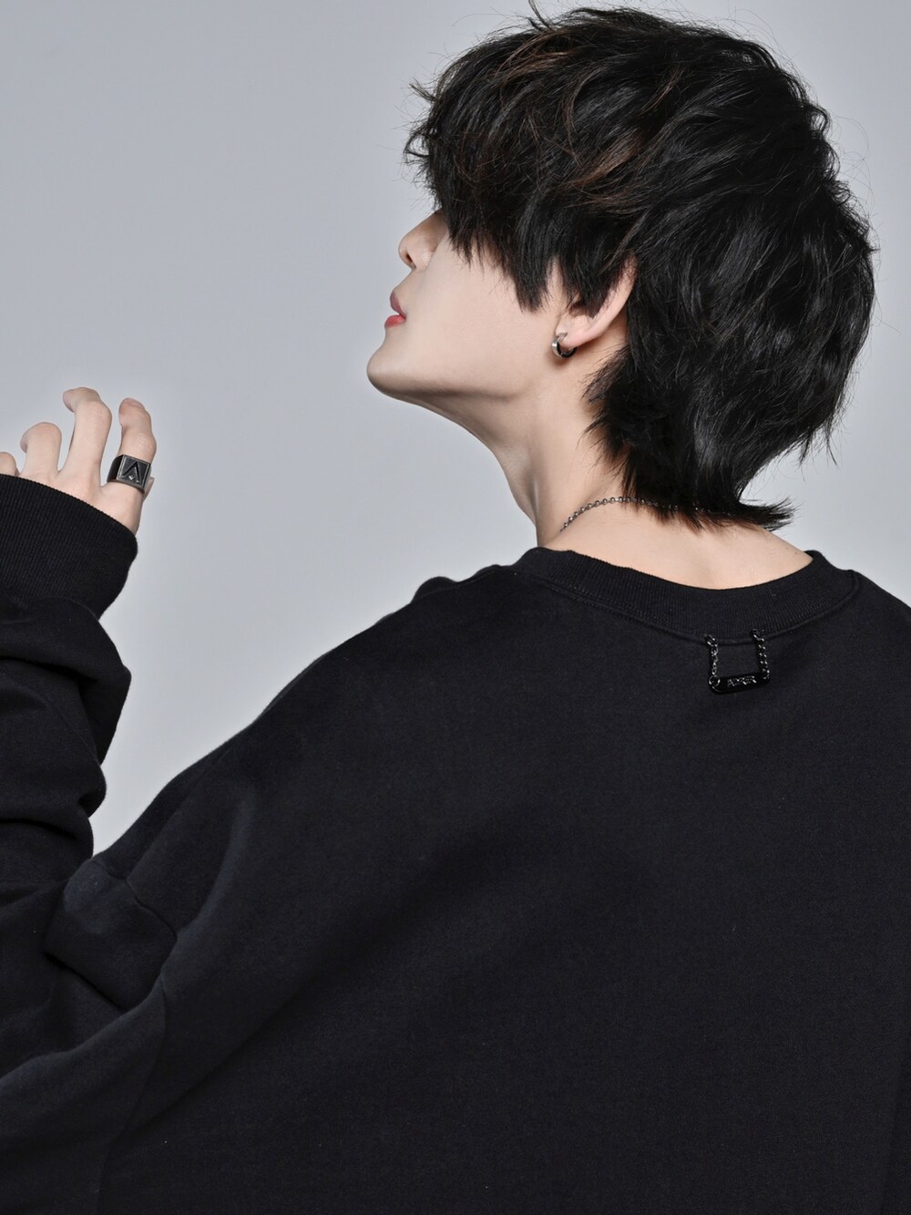 ブラック系のスウェット、ベージュ系のデニムパンツ、ブラック系のスニーカーを着用したメンズの冬コーディネートの5枚目の写真