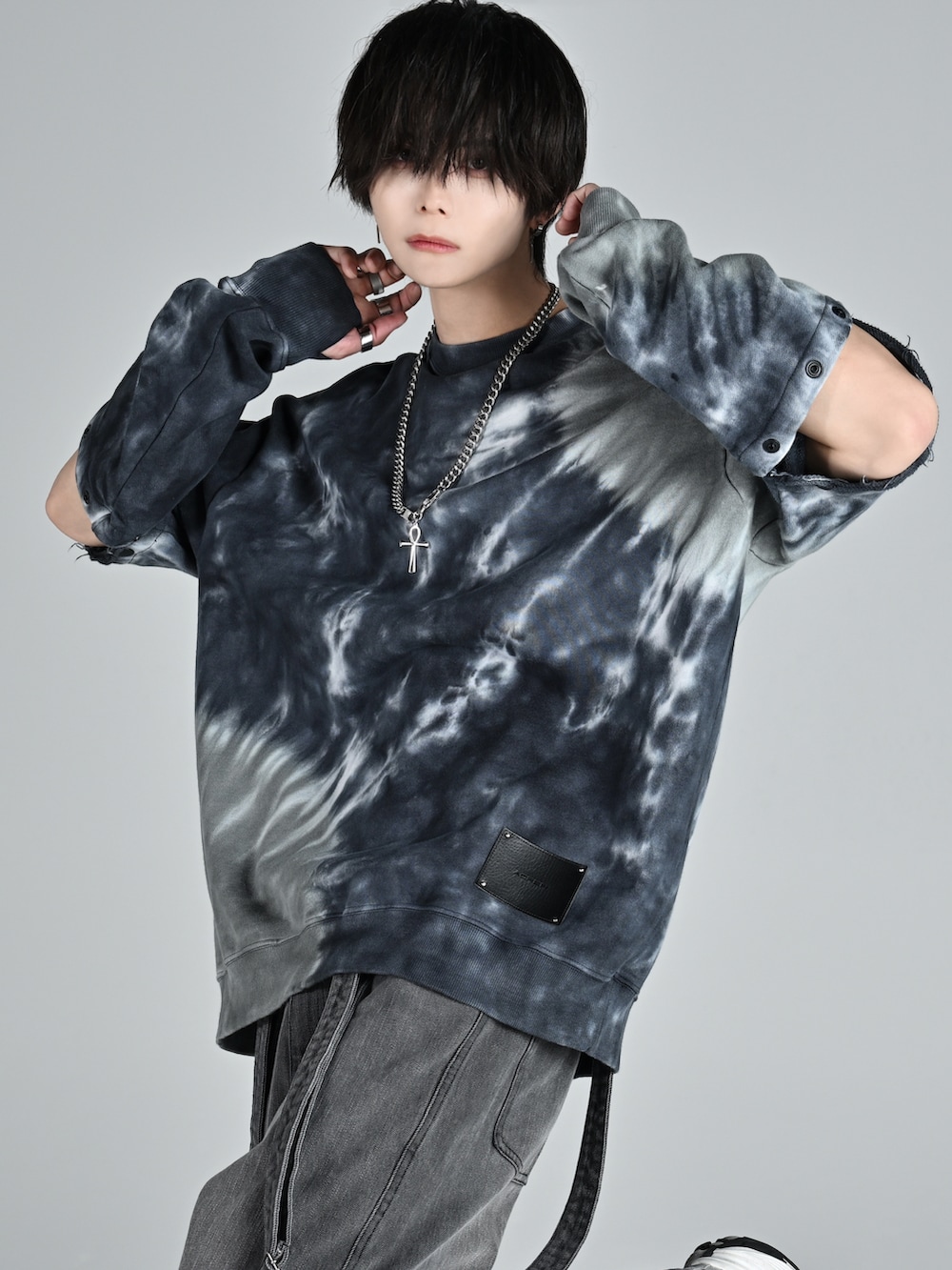 グレー系のスウェット、グレー系のデニムパンツ、ホワイト系のスニーカーを着用したメンズの冬コーディネートの2枚目の写真