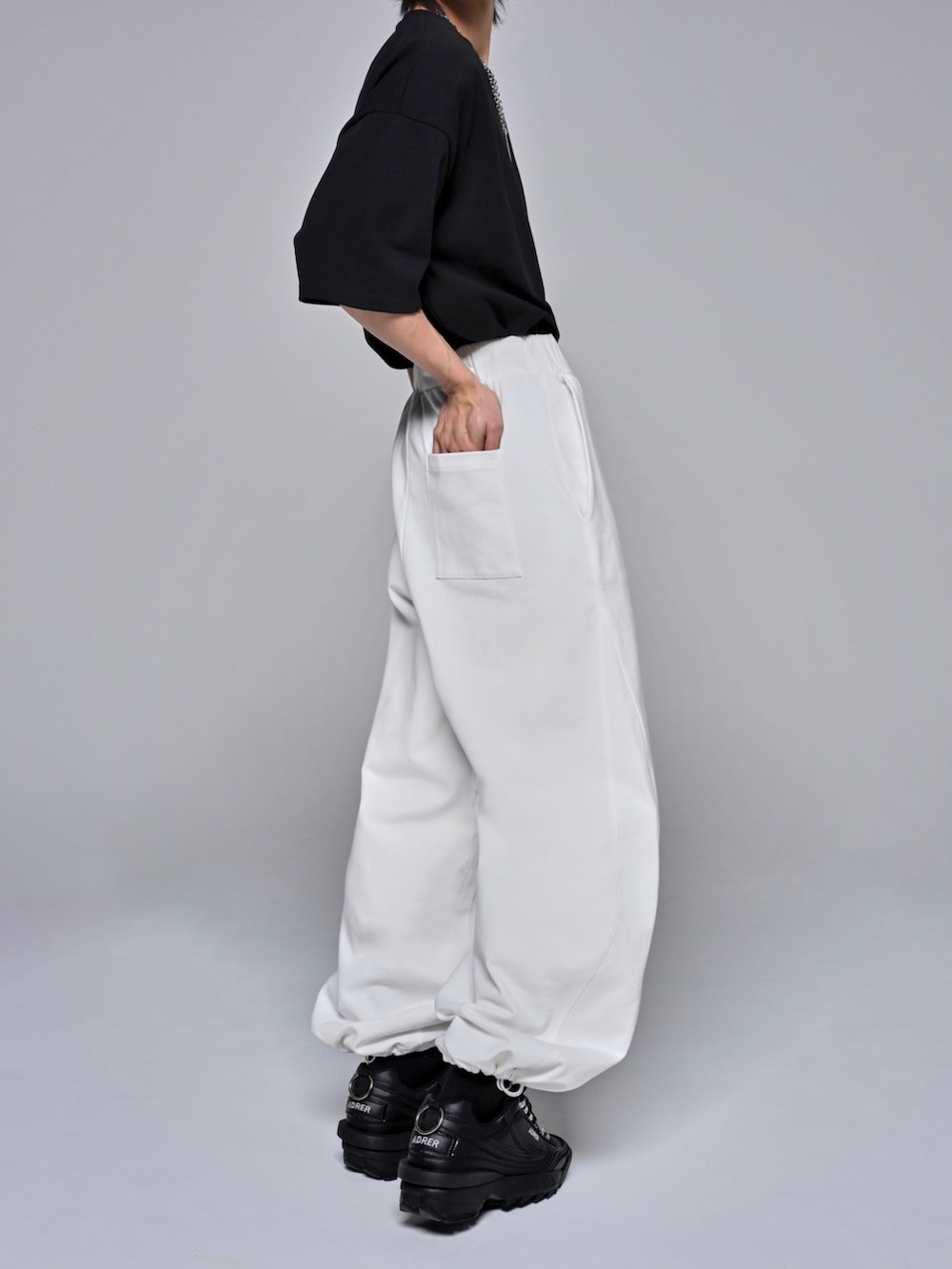 ブラック系のTシャツ/カットソー、ブラック系のスニーカー、ホワイト系のスウェットパンツを着用したメンズの夏コーディネートの5枚目の写真