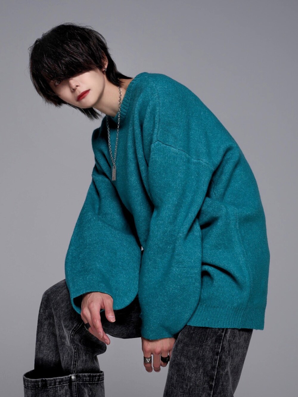 ブラック系のデニムパンツ、ブラック系のスニーカー、グリーン系のニット/セーターを着用したメンズの秋コーディネートの5枚目の写真