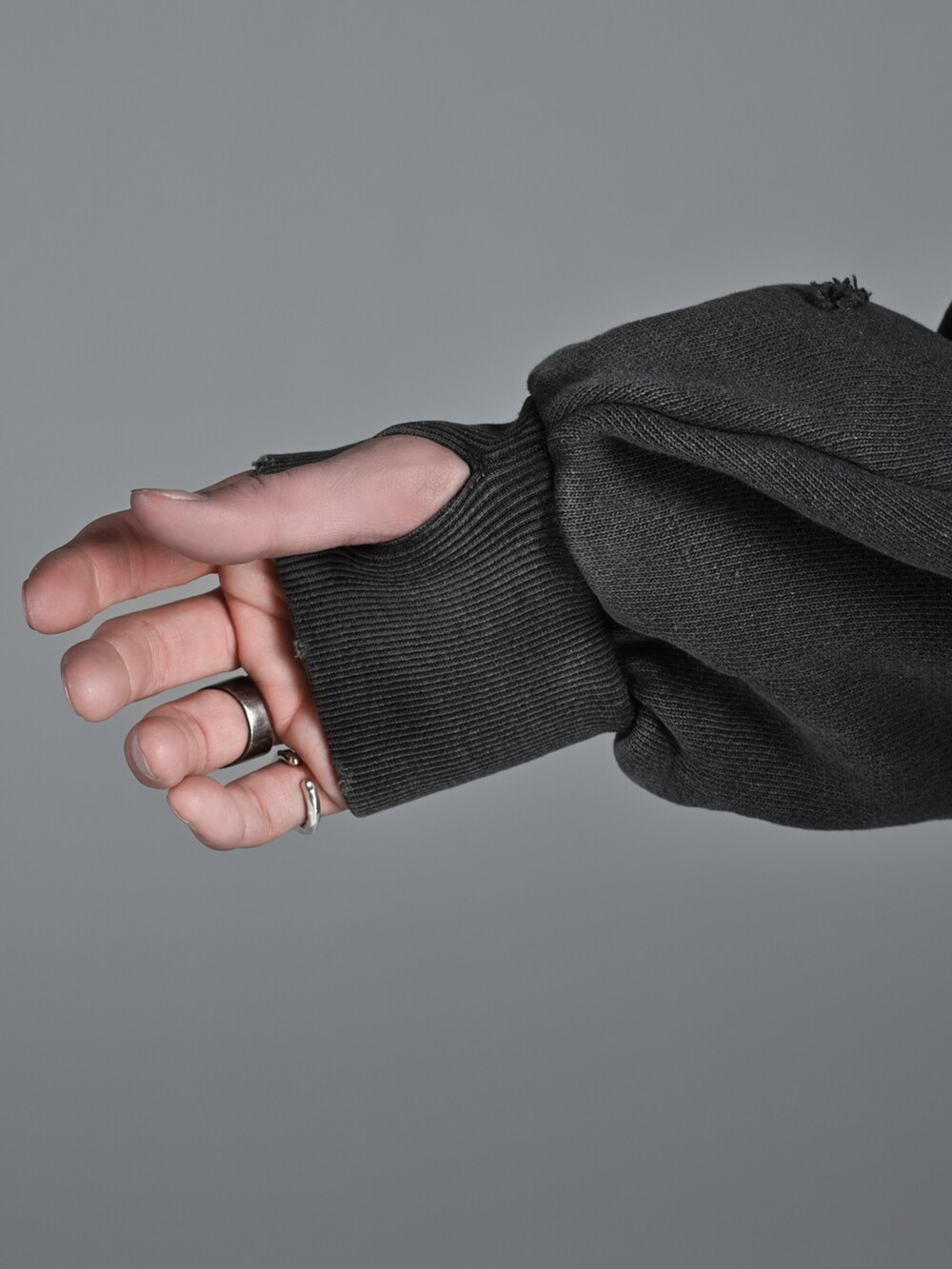 グレー系のスウェット、グレー系のデニムパンツ、シルバー系のネックレスを着用したメンズの冬コーディネートの4枚目の写真