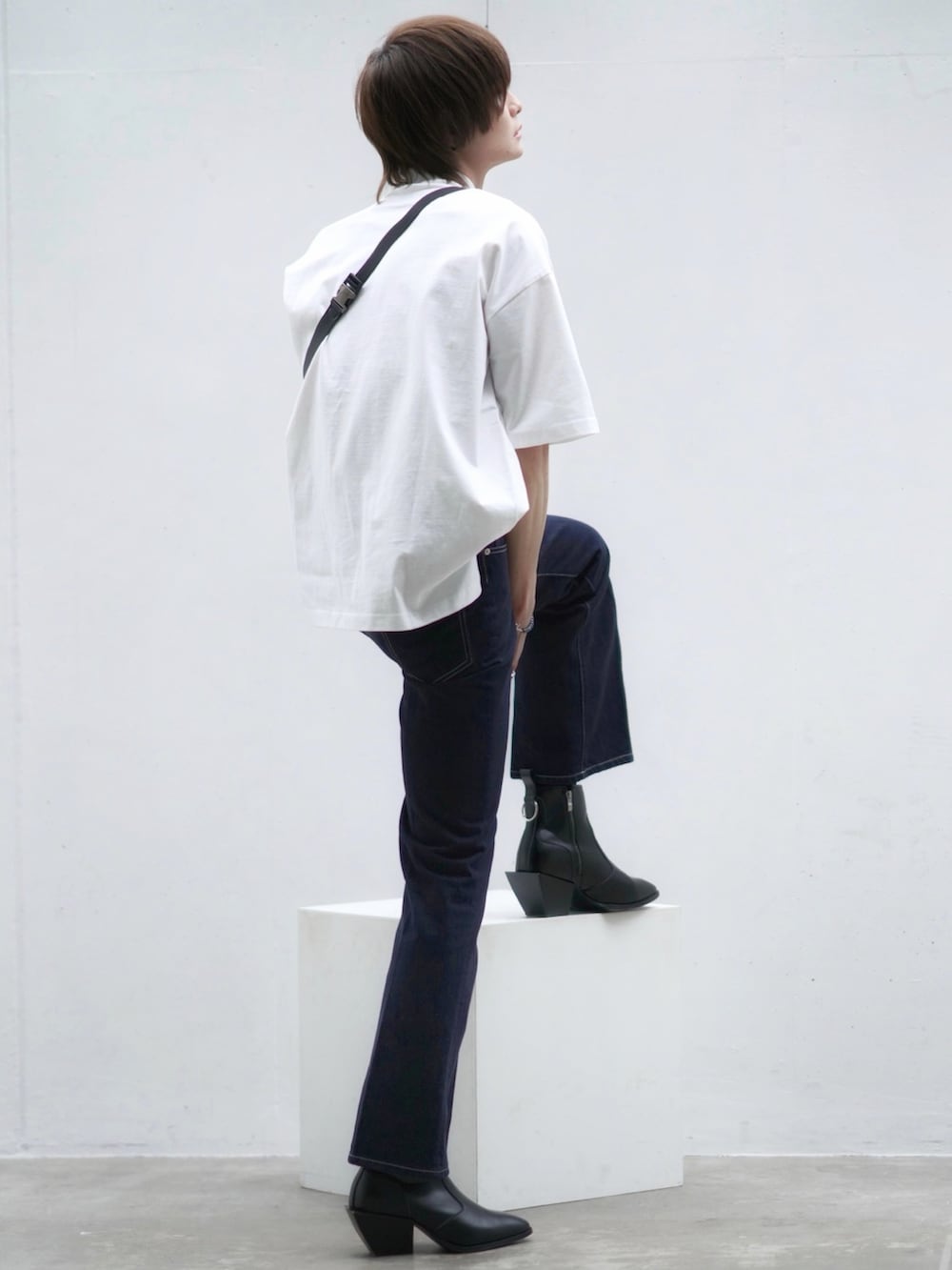 ブラック系のテーラードジャケット、ブルー系のデニムパンツ、ブラック系のブーツを着用したメンズの春コーディネートの4枚目の写真